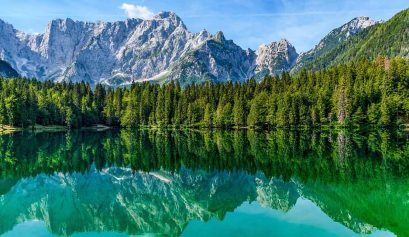 Lago con sfondo montagne e alberi - Giornata mondiale dell'ambiente AERA