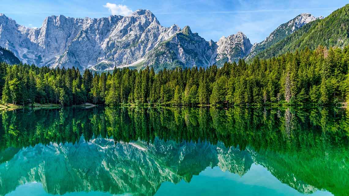 Lago con sfondo montagne e alberi - Giornata mondiale dell'ambiente AERA